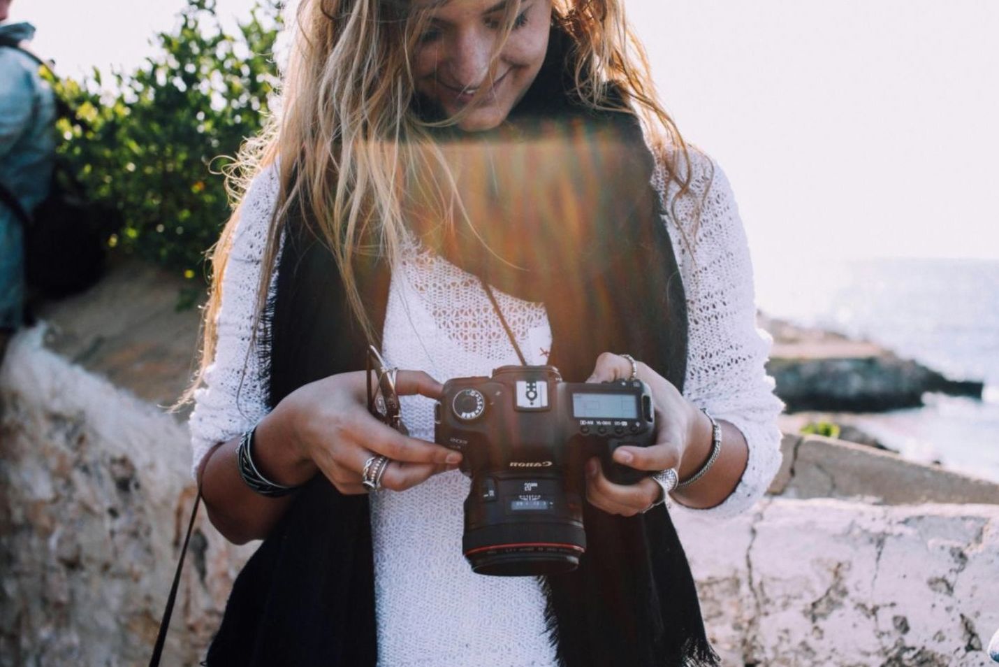 Photographer adjusting a large diffusion panel in an outdoor shoot